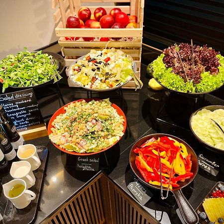 Royal Tulip Warsaw Centre 아파트 호텔 외부 사진 The photo shows a well-arranged salad bar featuring a variety of fresh salads and ingredients. There are several bowls and dishes with different types of salads, including green salads and grain salads. 

1. **Green Salads**: There are multiple bowls